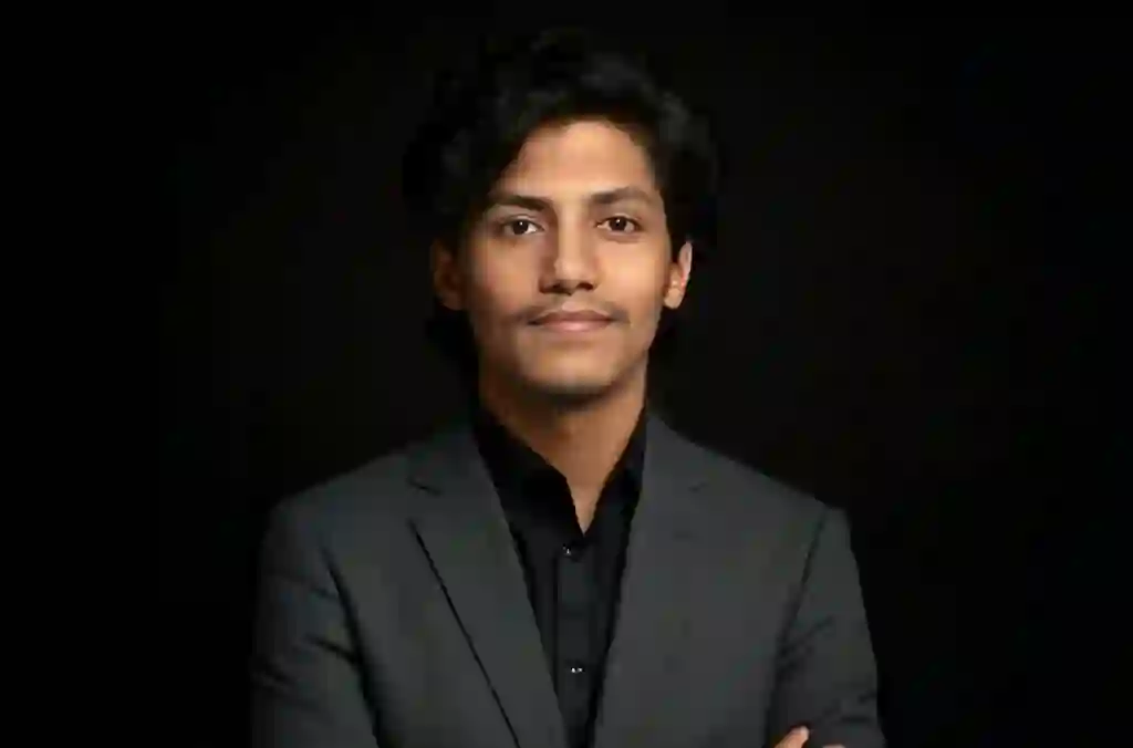 Photo of MD Rahat, Director of Graphic Design & Branding, posing in a formal suit against a dark background.